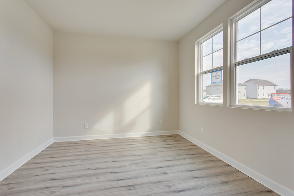 A room with windows and a wood floor.