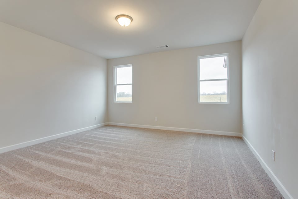 A room with a wood floor and a light on the wall.