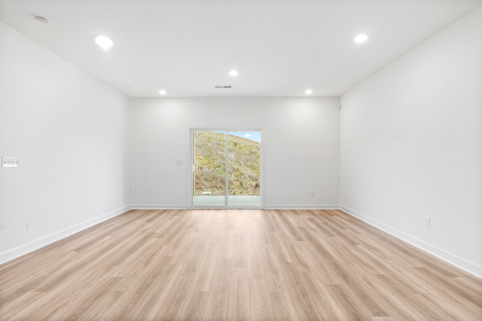 A room with a wood floor and a window.