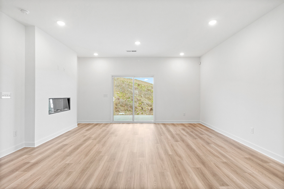A room with a wood floor and a window.
