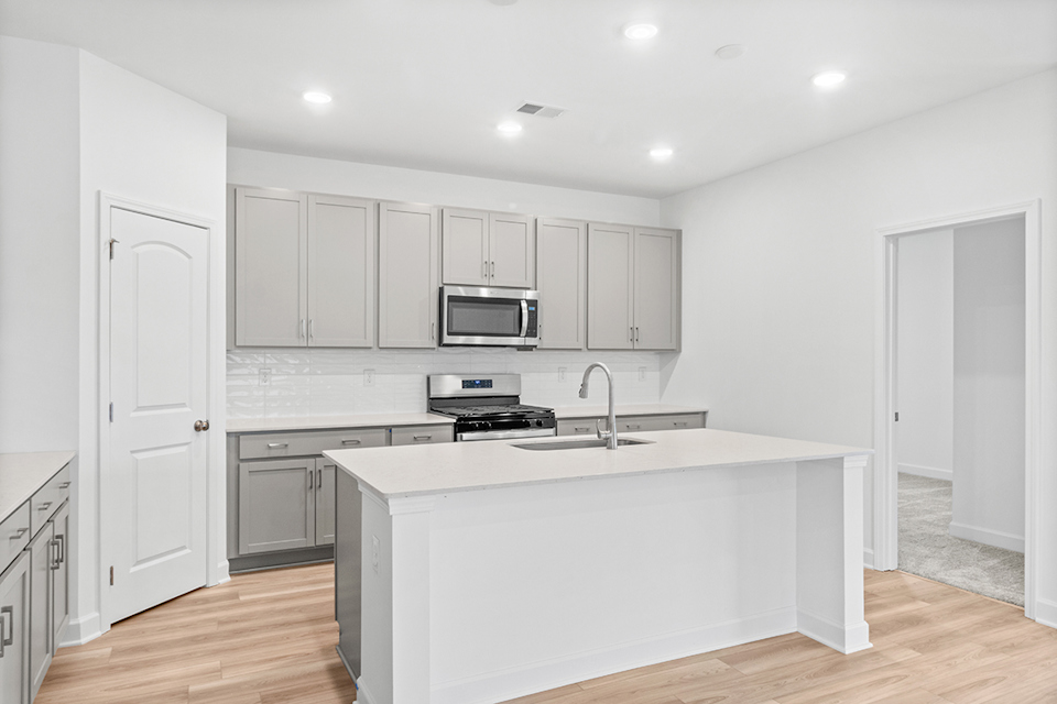 A kitchen with white cabinets.