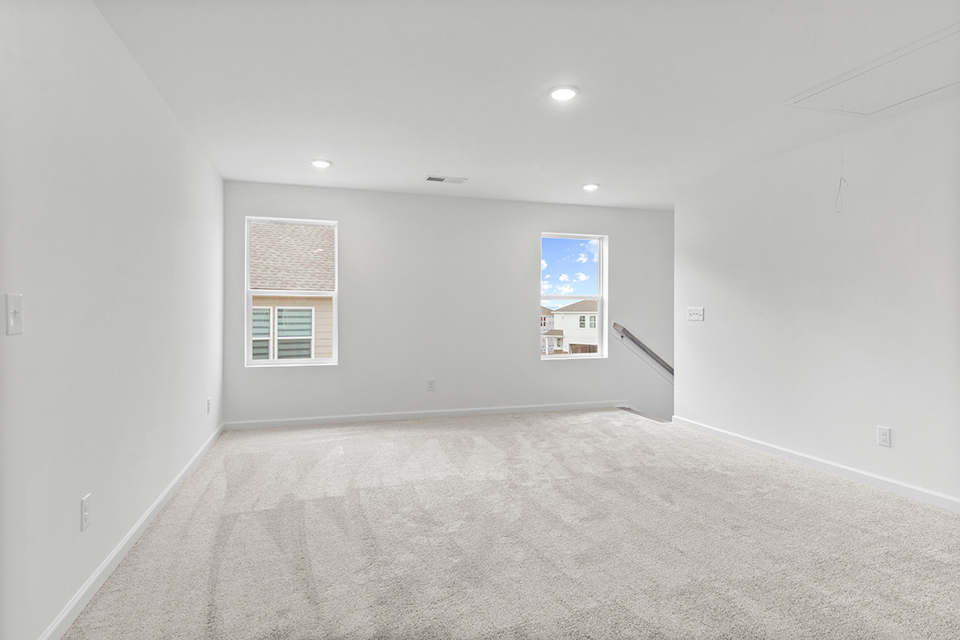 A room with a white carpet and a window.