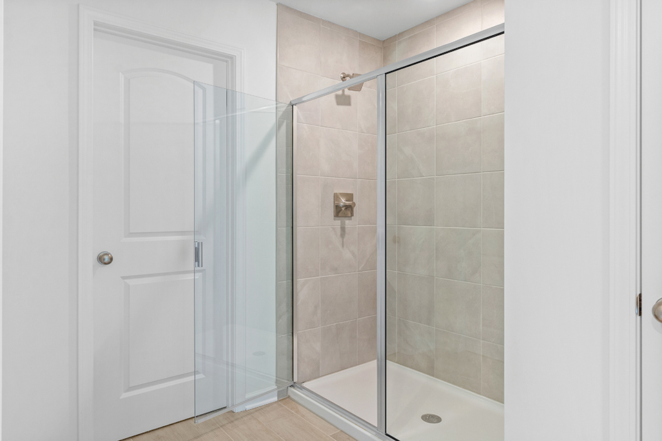 A bathroom with a shower unit and a bathtub.
