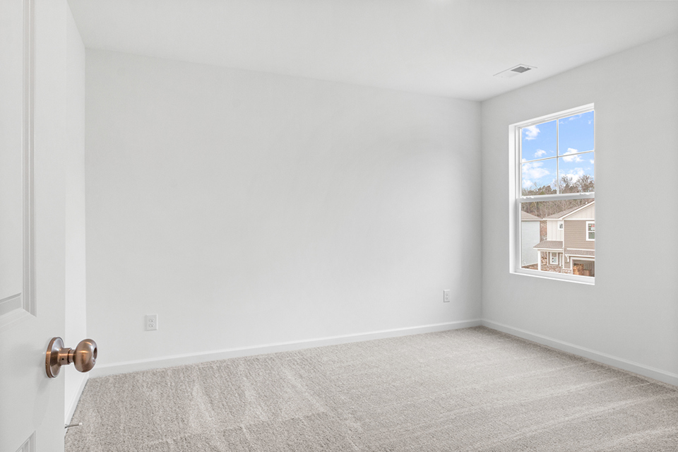 A room with a window and carpet.