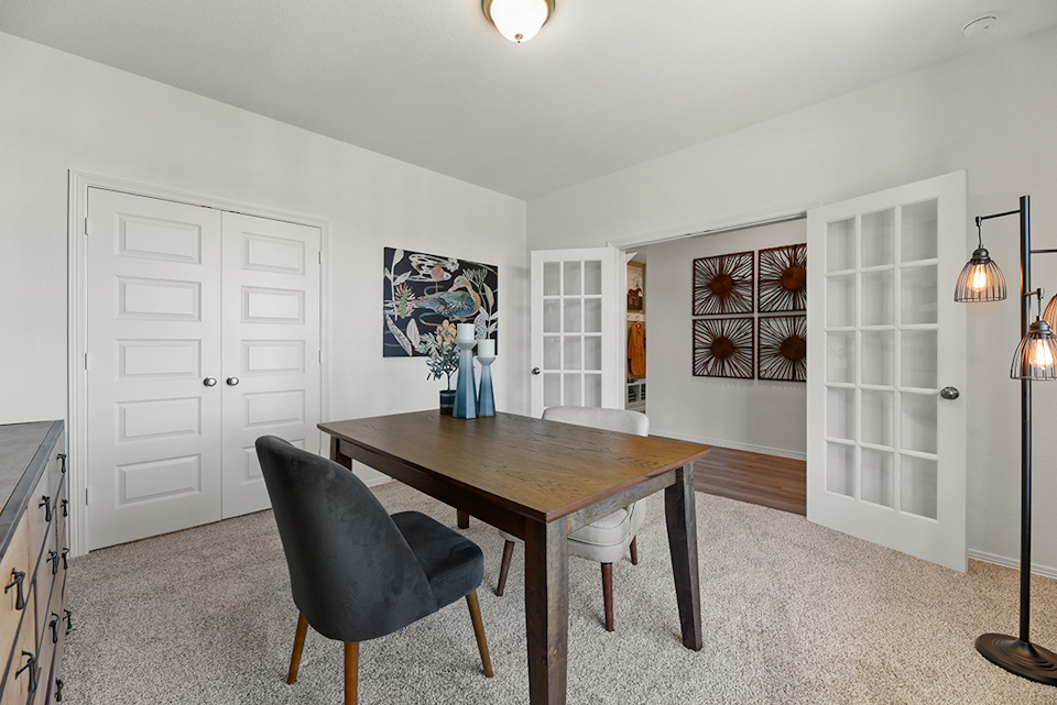 A dining room with a table and chairs.