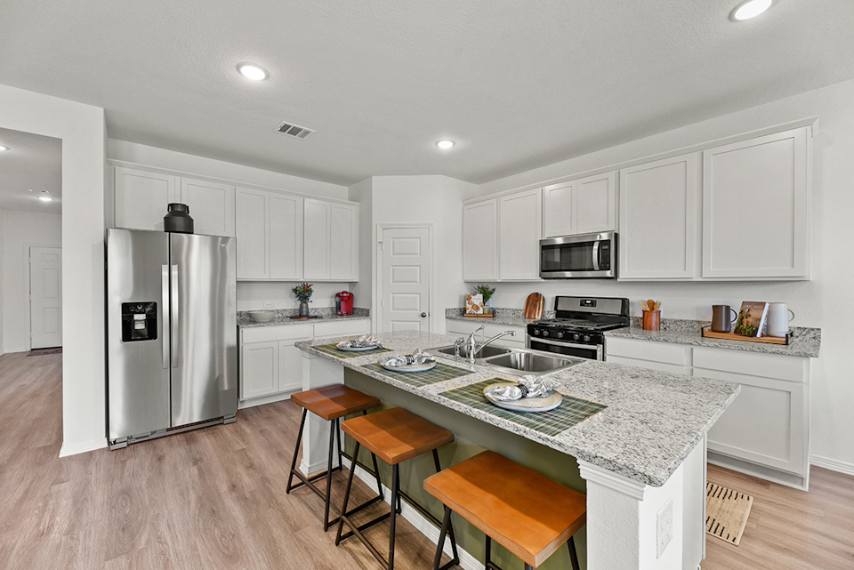 A kitchen with white cabinets.