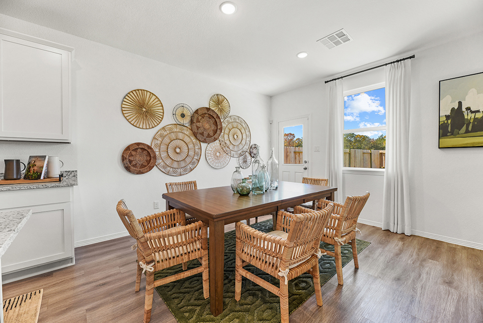 A dining room with a table and chairs.