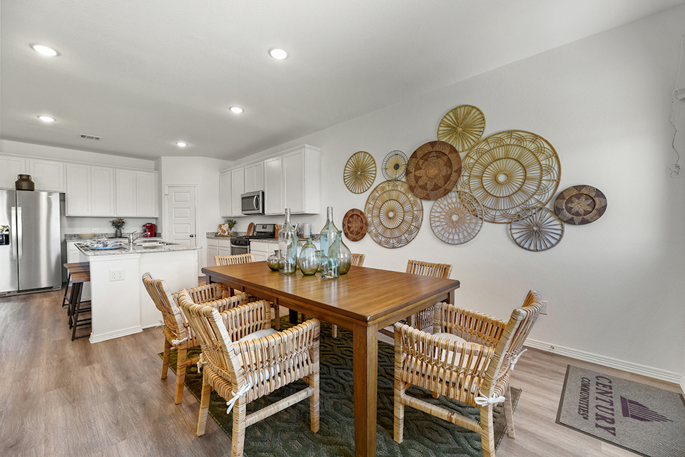 A kitchen with a table and chairs.