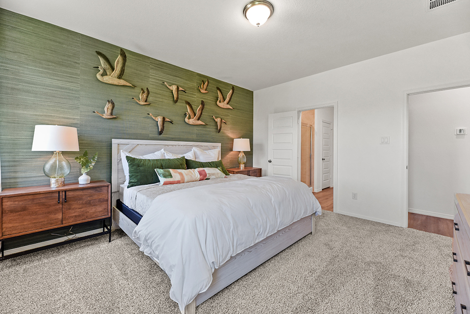 A bedroom with a bed and a lamp.