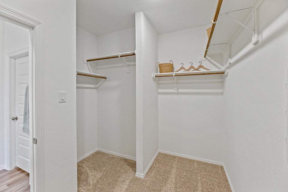 A room with a shelf and a basket on the wall.
