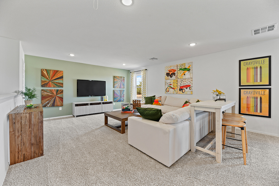 A living room with a white couch and a tv.