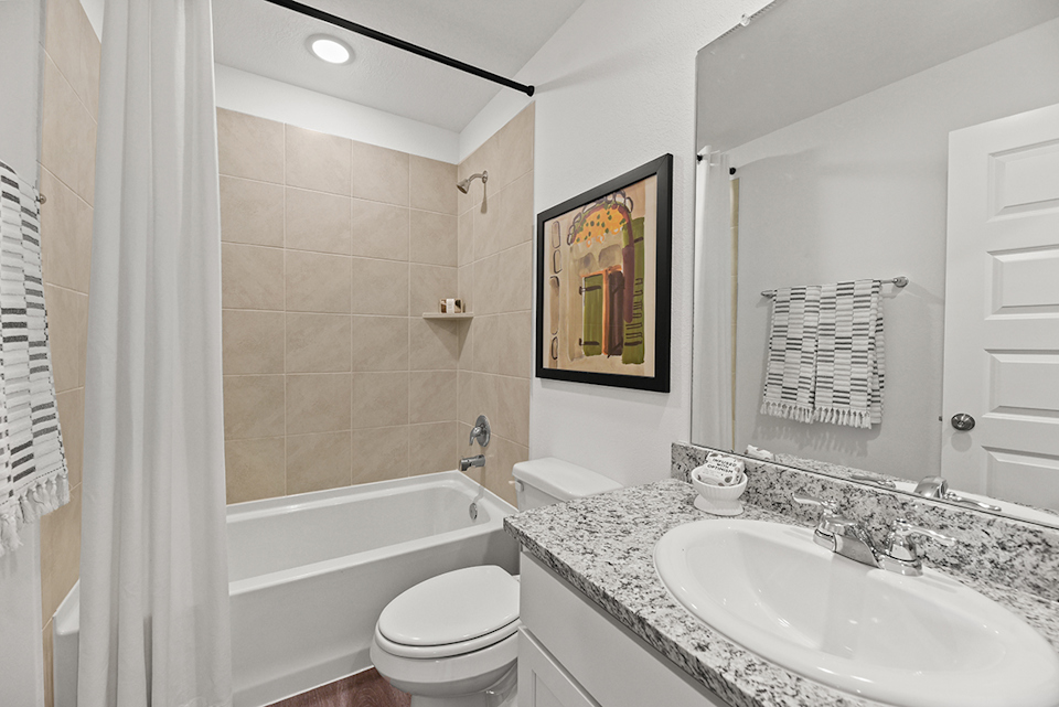 A bathroom with a tub sink and toilet.