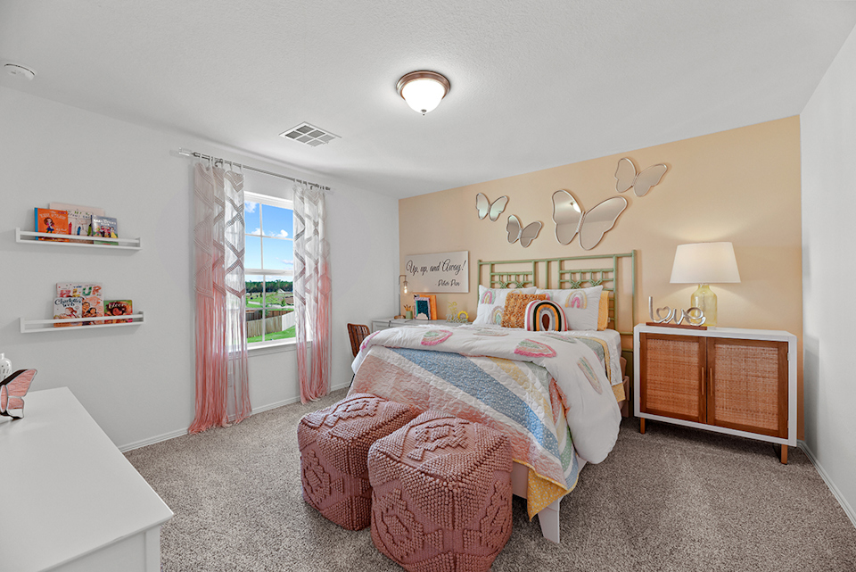 A bedroom with a bed and a chair.