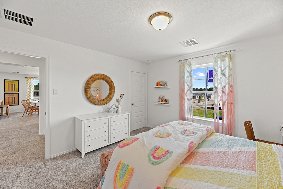 A bedroom with a large mirror.