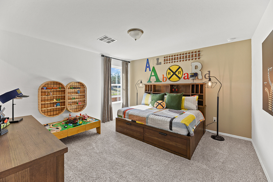 A bedroom with a bed and desk.