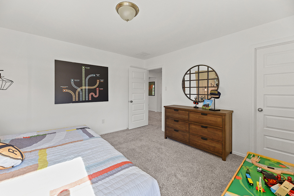 A bedroom with a bed and dresser.