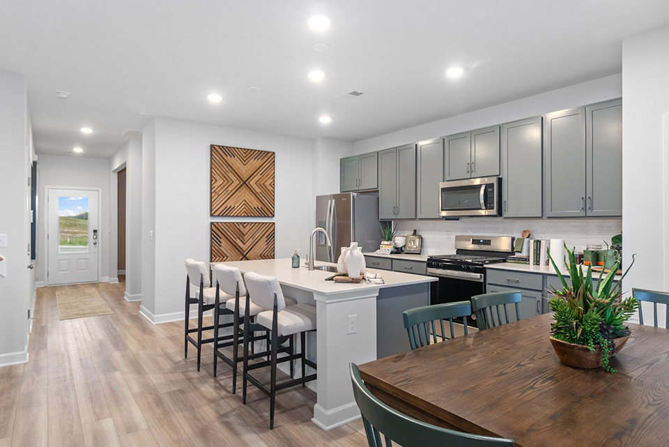 A kitchen with a dining table and chairs.