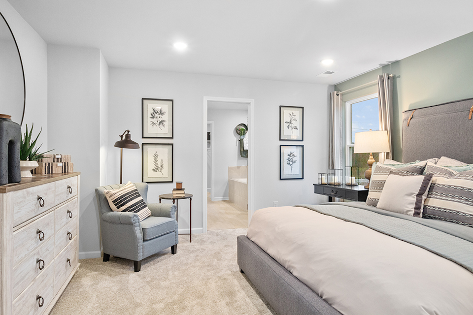A bedroom with a bed and a chair.
