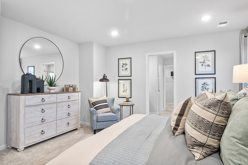 A bedroom with a bed and a chair.
