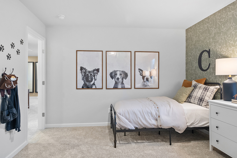 A bedroom with a bed and a lamp.