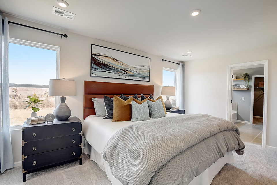 A bedroom with a bed and a lamp.