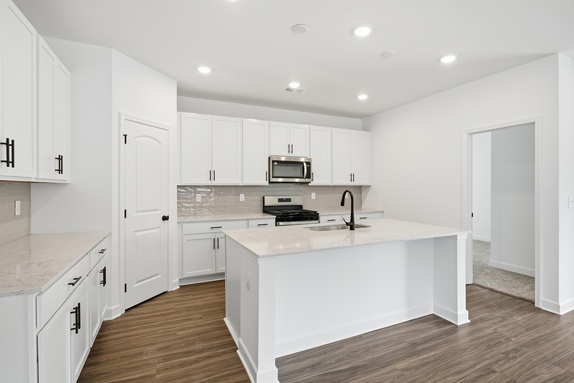 A kitchen with white cabinets.