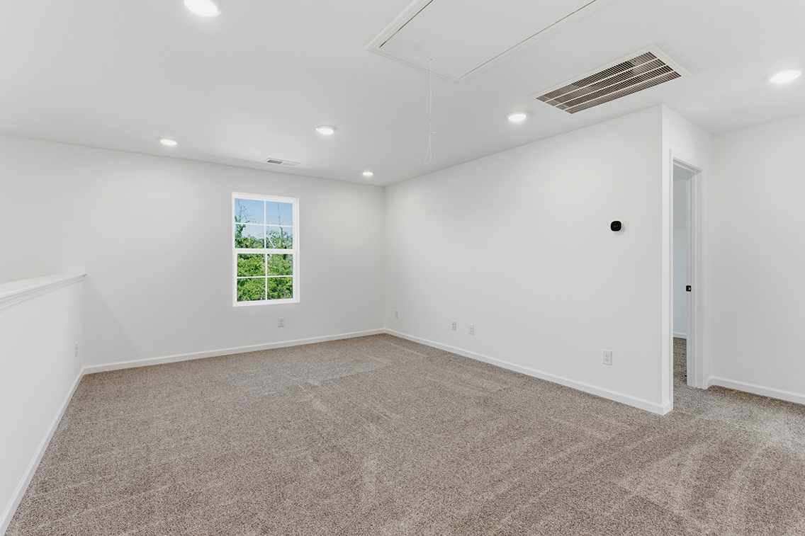 A room with a window and a carpet.