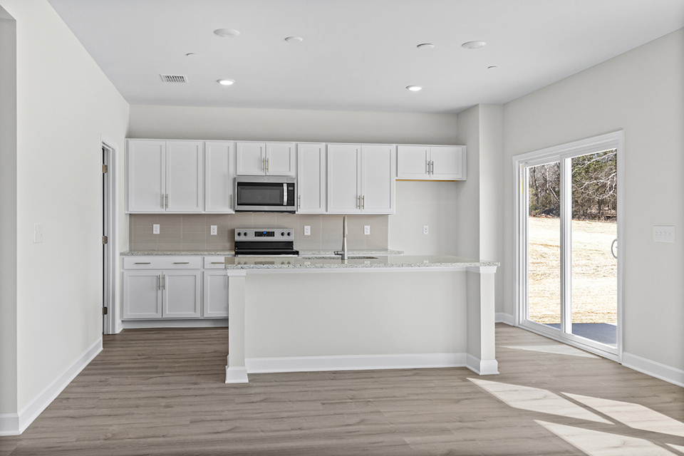 A kitchen with white cabinets.