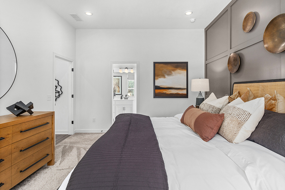 A bedroom with a bed and a lamp.