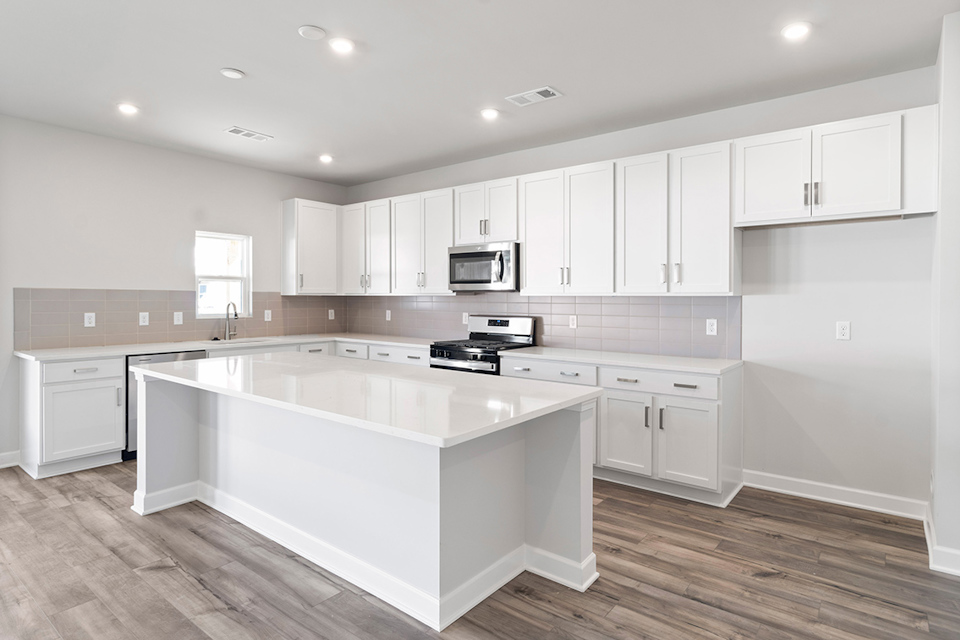 A kitchen with white cabinets.