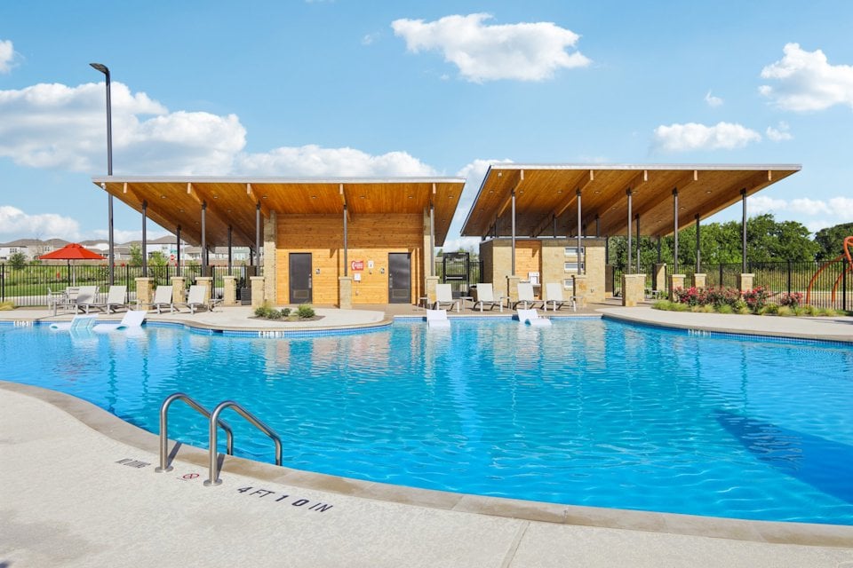 A swimming pool with a building in the background.