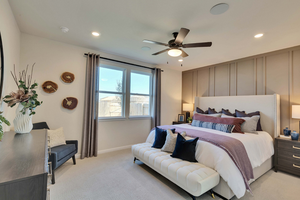 A bedroom with a bed and a fan.