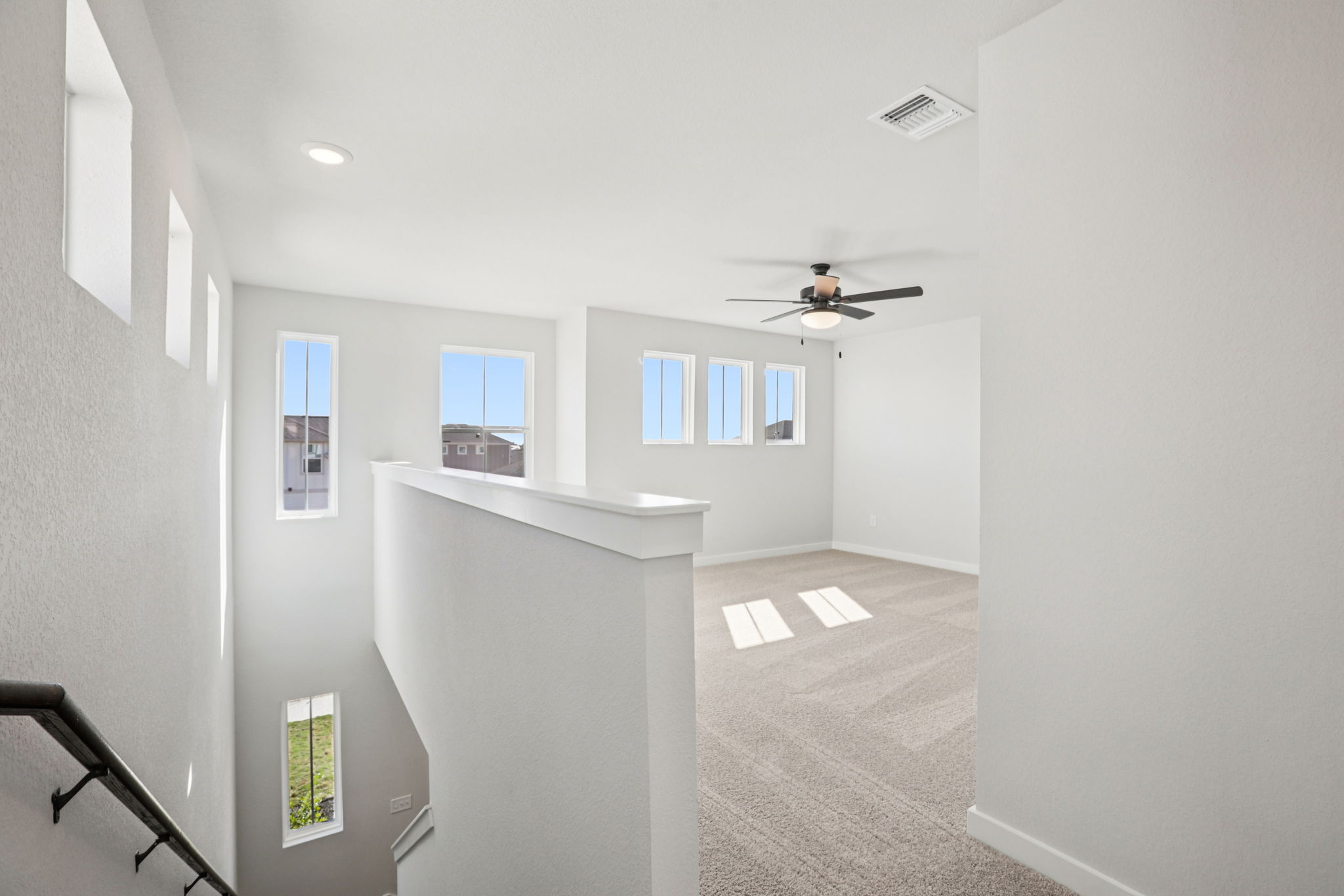 A room with a fan and a window.