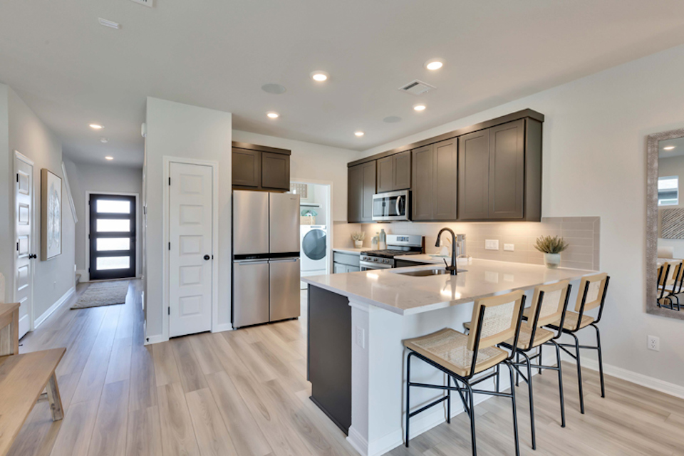 A kitchen with a table and chairs.
