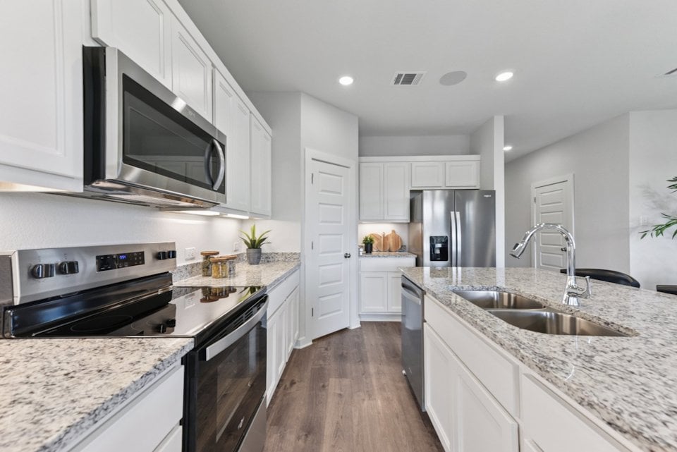A kitchen with white cabinets.