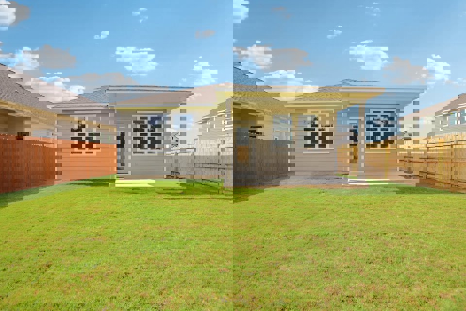 A house with a fence and grass.