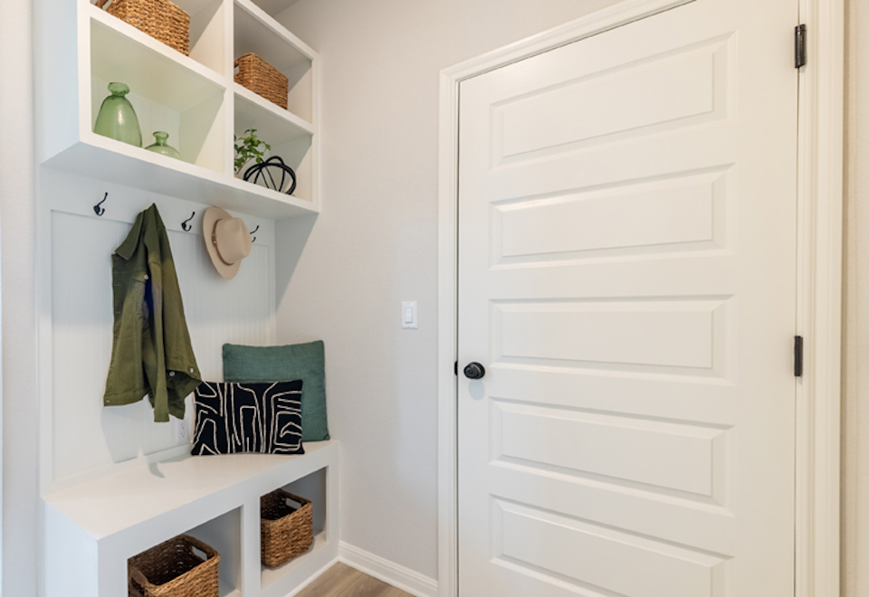 A white closet with a green pillow.