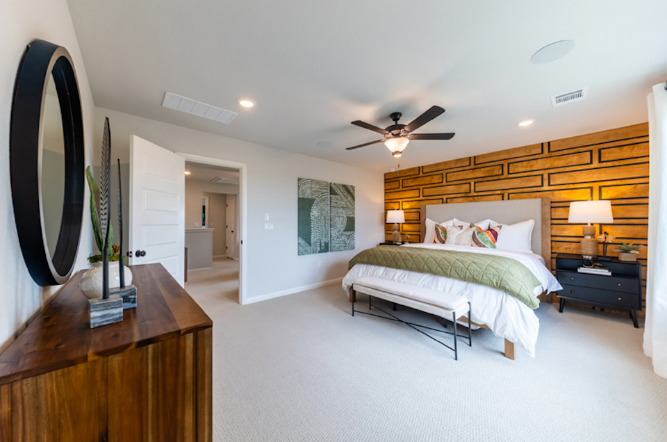 A bedroom with a bed and lamps.
