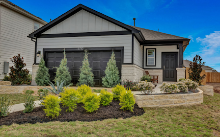 A house with a garden in the front yard.