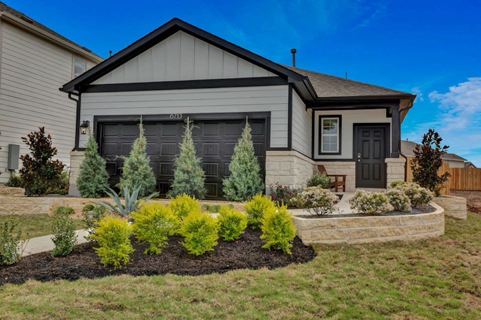 A house with a garden in the front yard.