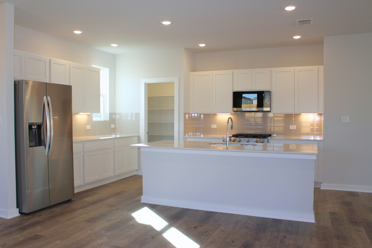 A kitchen with white cabinets.