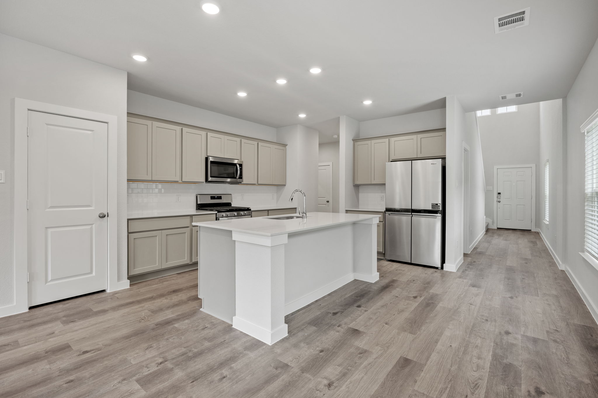 A kitchen with white cabinets.
