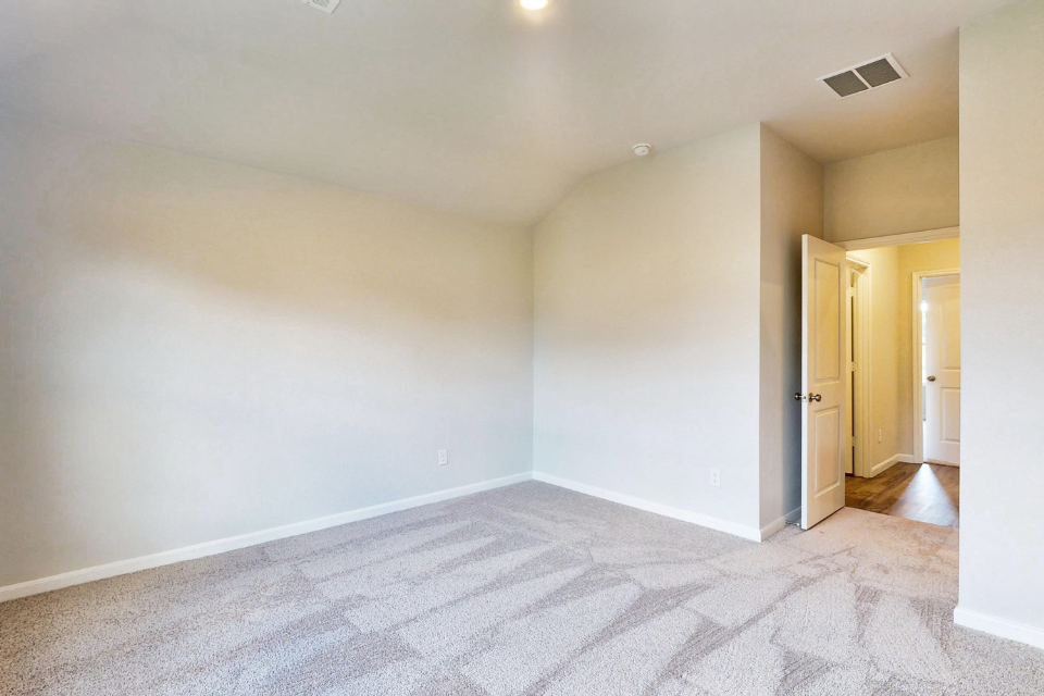 A room with a carpet and a door.