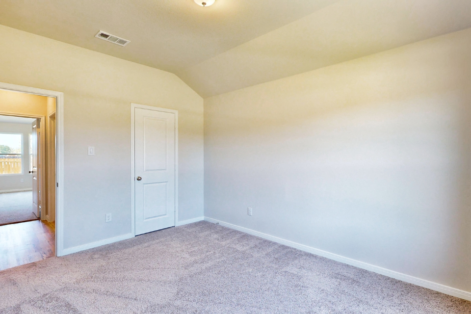 A room with a white wall and a door.
