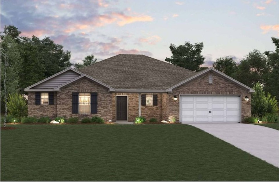A house with a garage and a lawn in front of it.