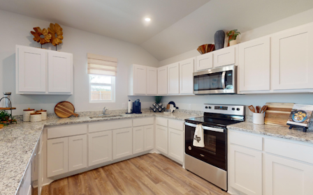 A kitchen with white cabinets.
