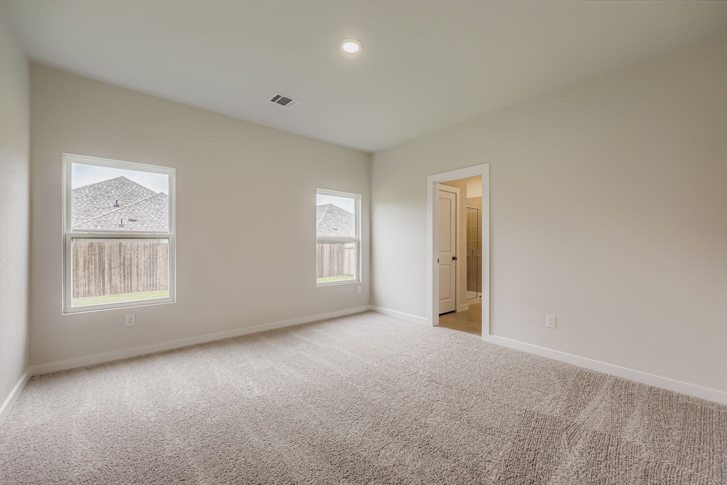 A room with a carpet and a door.