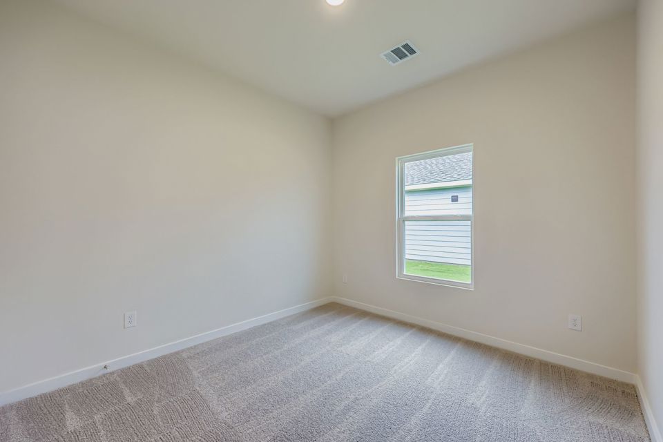 A room with a carpet and a window.