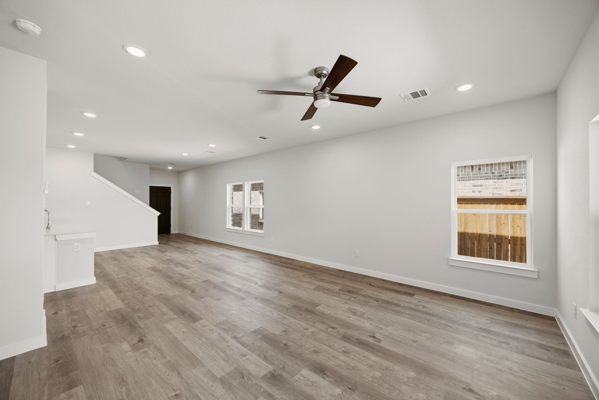 A room with a wood floor and a ceiling fan.