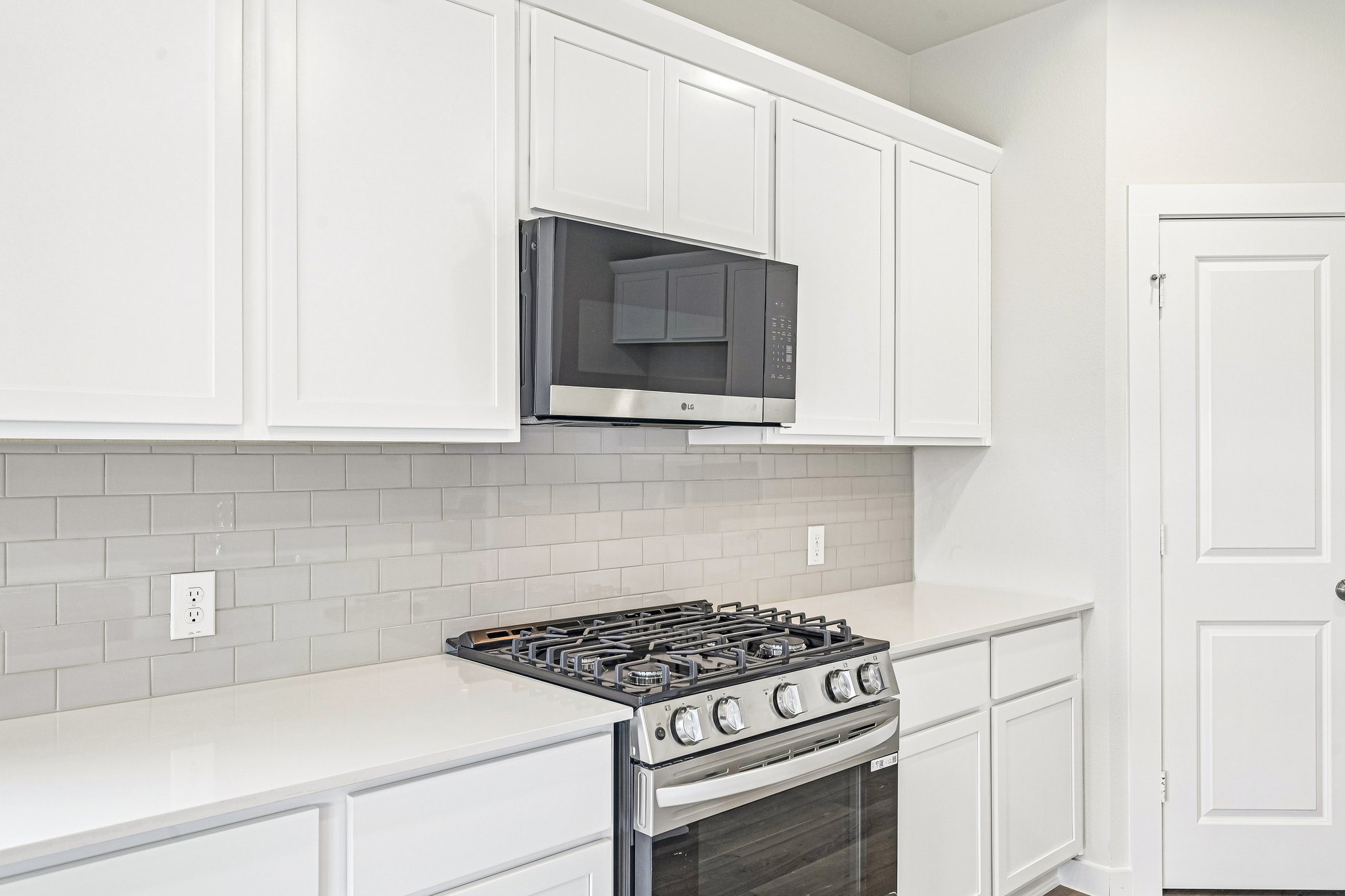 A kitchen with white cabinets.
